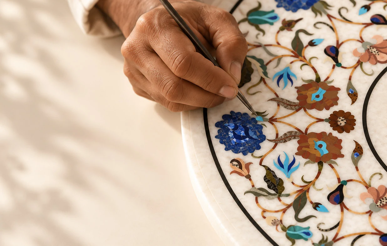 An artisan carefully working by hand on a floral Pietra Dura marble inlay.